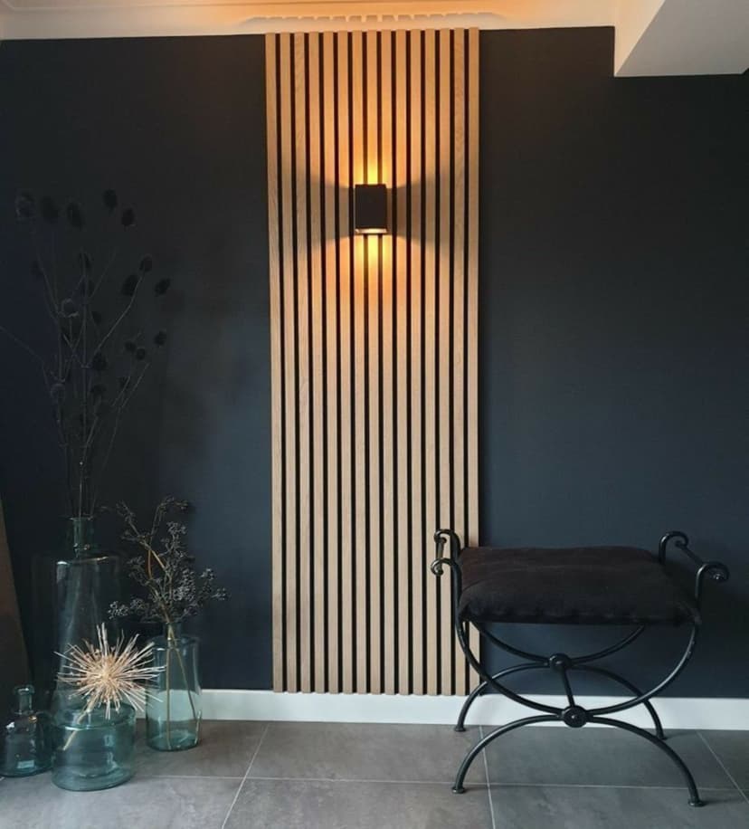 Natural oak finish WPC wall panels installed behind sconce in cozy corner